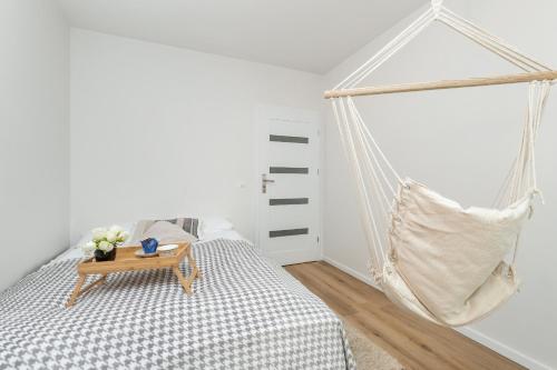 a bedroom with a swing bed and a table at Cosy Apartment with Terrace and Parking in Rumia by Rent like home in Rumia