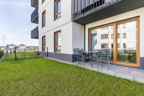 a patio with chairs and a table in front of a building at Cosy Apartment with Terrace and Parking in Rumia by Rent like home in Rumia