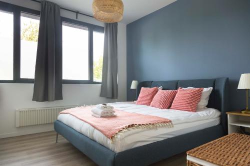 een slaapkamer met blauwe muren en een bed met roze kussens bij Brussels EU Design Residence in Brussel