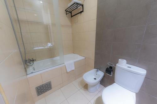 a bathroom with a toilet and a shower and a sink at Olympic Inn Casablanca in Casablanca