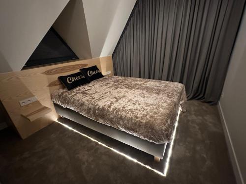 a small bedroom with a bed with a light on it at Skyline Villa with jacuzzi and sauna in Kościelisko