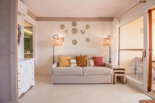 uma sala de estar com um sofá e dois candeeiros em Portisco Bouganville Seaside Charm Flat W/ Veranda em Marina di Portisco