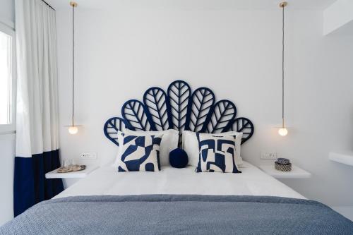 a bedroom with a bed with blue and white pillows at Croco Mykonos in Tourlos