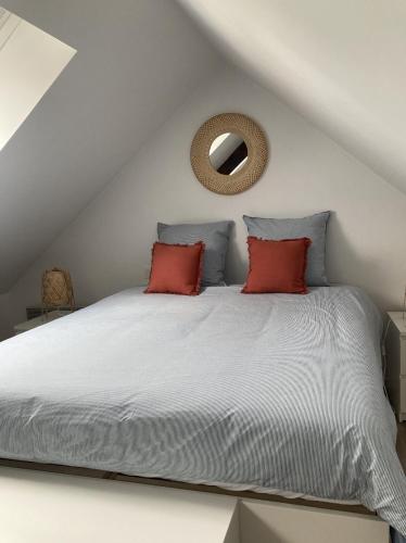 um quarto com uma cama com duas almofadas vermelhas em Chez David et Bene em Rennes