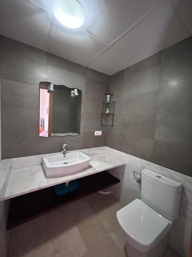 ein Badezimmer mit einem weißen WC und einem Waschbecken in der Unterkunft BAHIA alquiler solo para familias in Playa de Gandia