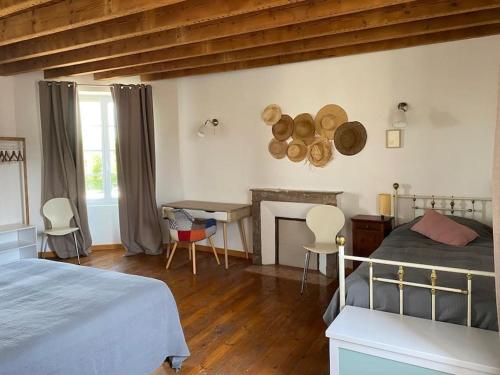 une chambre avec un lit, une table et une cheminée dans l'établissement La Belle Etape grand gîte familial, 10min du Puy duFou, à Saint-Mars-la-Réorthe