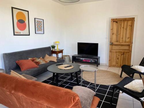 un salon avec un canapé et une table dans l'établissement La Belle Etape grand gîte familial, 10min du Puy duFou, à Saint-Mars-la-Réorthe