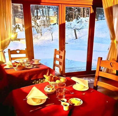 a table with a red table cloth on it with a view at HOTEL LA NIGRITELLA in Bardonecchia