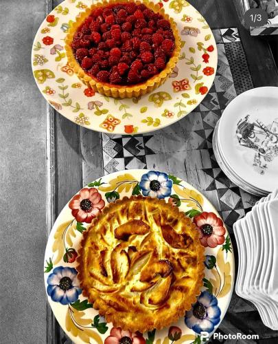 two plates of food on a table with a raspberry pie at HOTEL LA NIGRITELLA in Bardonecchia