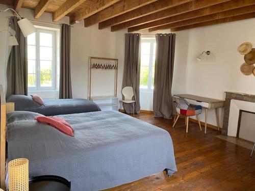 une chambre avec deux lits et une cheminée dans l'établissement La Belle Etape grand gîte familial, 10min du Puy duFou, à Saint-Mars-la-Réorthe