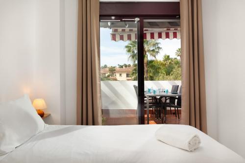 een slaapkamer met een bed en uitzicht op een tafel bij Riviera Park Great Escape by Alfresco Stays in Mijas Costa