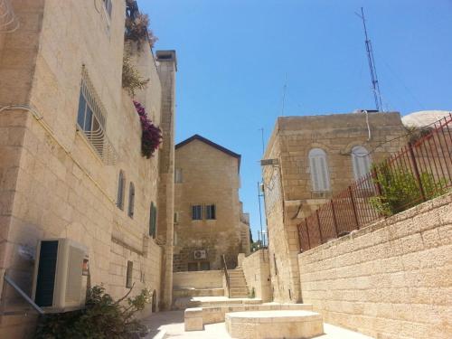 an alley between two old stone buildings with stairs at Glows in Jerusalem