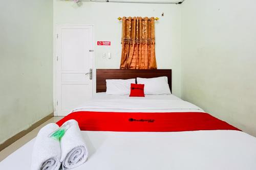een slaapkamer met een bed met twee handdoeken erop bij RedDoorz At Teratai Homestay Medan Amplas in Medan