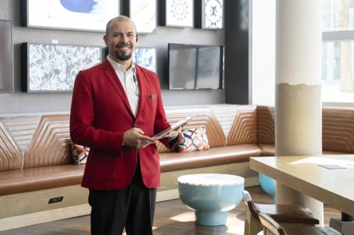 a man in a red suit standing in a room at San Jose Marriott in San Jose