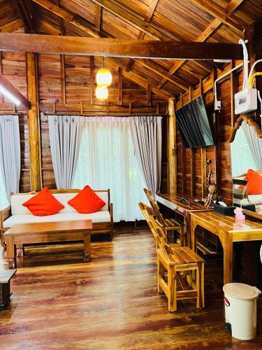 a living room with a couch and a desk at บ้านสวนแก้วคำแพง Baan Suan Kaew Khampaeng in Udon Thani