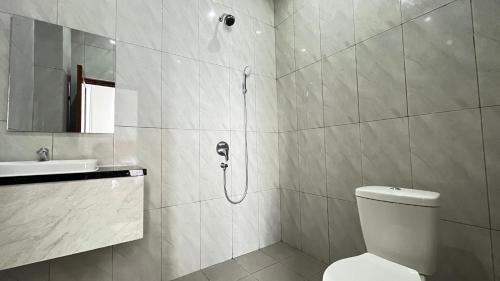 a bathroom with a shower and a toilet and a sink at RedDoorz Premium at Jalan Diponegoro Lampung in Bandar Lampung