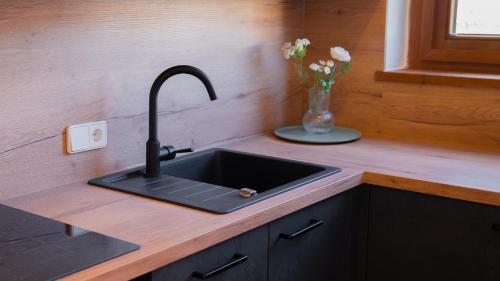 a kitchen counter with a sink and a vase of flowers at Eva Apartments - Bergisel in Innsbruck