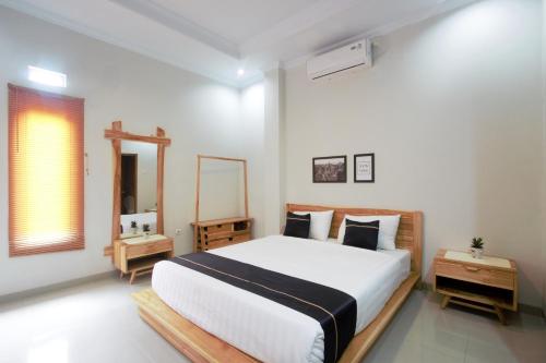 een slaapkamer met een groot bed en een spiegel bij Cendhani Raras Residence in Demangan