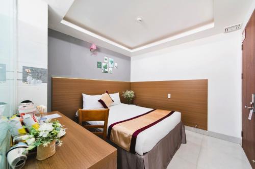 a hotel room with a bed and a table at Arise Seaside Hotel in Nha Trang