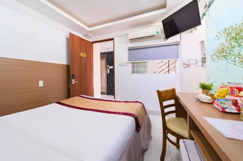 a hotel room with a bed and a desk and a table at Arise Seaside Hotel in Nha Trang
