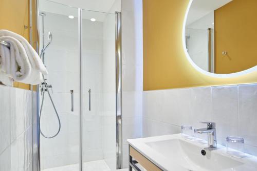 a bathroom with a shower and a sink and a mirror at Hôtel Bordeaux Clémenceau by Happyculture in Bordeaux