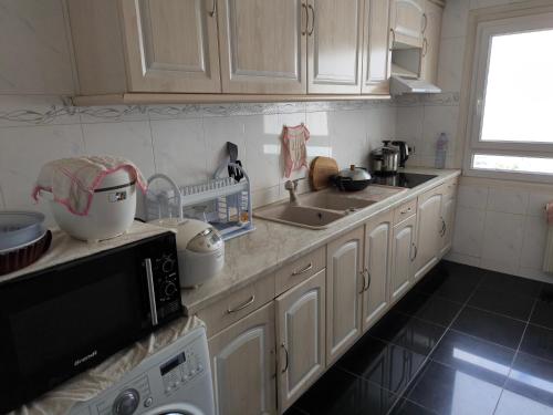 une cuisine avec des armoires blanches et un comptoir dans l'établissement Lovely Appartment In Paris - Near Arena Porte de la Chapelle, à Paris