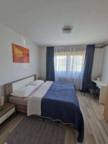 a bedroom with a large bed with a blue blanket at Rooms & Apartment Milan Saborsko in Saborsko