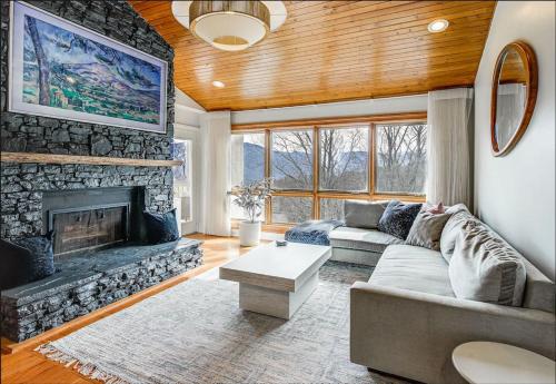a living room with a couch and a fireplace at Lux Retro Getaway w/ Ober & Smoky Mtn Views! in Gatlinburg