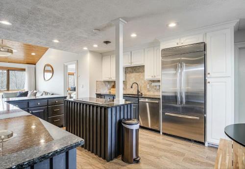 a large kitchen with a stainless steel refrigerator at Lux Retro Getaway w/ Ober & Smoky Mtn Views! in Gatlinburg