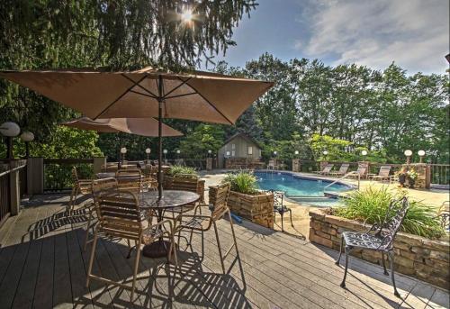 a patio with a table and chairs and a pool at Lux Retro Getaway w/ Ober & Smoky Mtn Views! in Gatlinburg