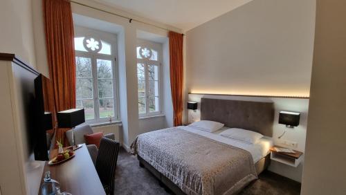 una camera da letto con un letto e due finestre di Schloss Schlemmin a Schlemmin