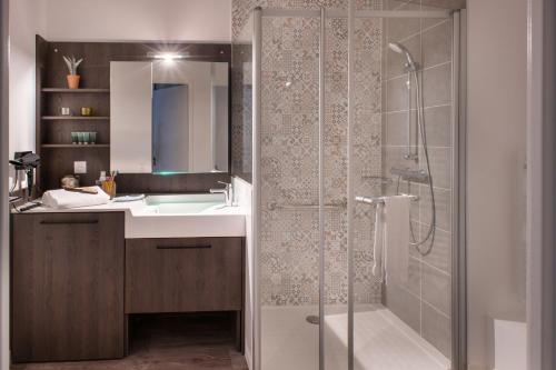 La salle de bains est pourvue d'une douche et d'un lavabo. dans l'établissement DOMITYS SARIA, à Serris