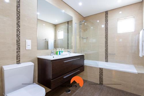a bathroom with a toilet and a sink and a shower at #214 Vivenda 3 Quartos by Home Holidays in Branqueira