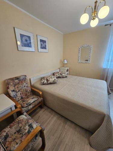 a bedroom with a large bed and a chair at Villa Krystyna in Dźwirzyno