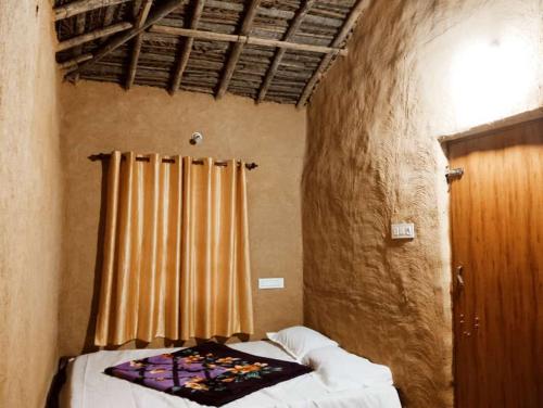 sypialnia z łóżkiem i oknem z zasłonami w obiekcie Cosmic Mud House Kanthalloor w mieście Kanthalloor