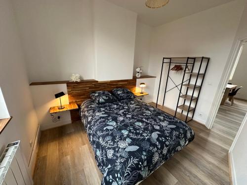 費康的住宿－Le Gîte Du Centre - Hypercentre，一间卧室配有一张床和一张带两盏灯的书桌。