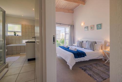 ein Schlafzimmer mit einem Bett und ein Badezimmer mit einer Badewanne in der Unterkunft Waterfront Cottage B3 in Swakopmund