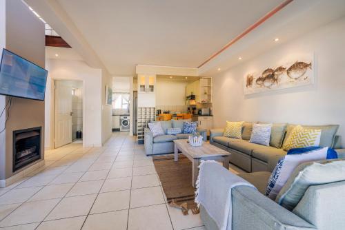 un soggiorno con divani blu e una TV di Waterfront Cottage B3 a Swakopmund
