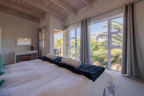 um quarto com uma cama grande e uma janela grande em Waterfront Cottage B3 em Swakopmund