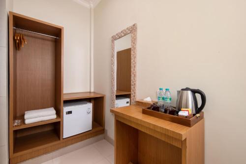 a bathroom with a vanity with a mirror and a sink at Angkul Angkul Segara Beach Kuta by Kamara in Kuta