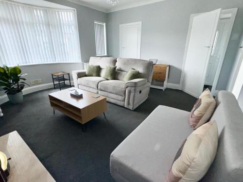 a living room with a couch and a coffee table at M1 Link 2 bed house up to 4 people, free parking,wifi,M1,transport links,garden in Sutton in Ashfield