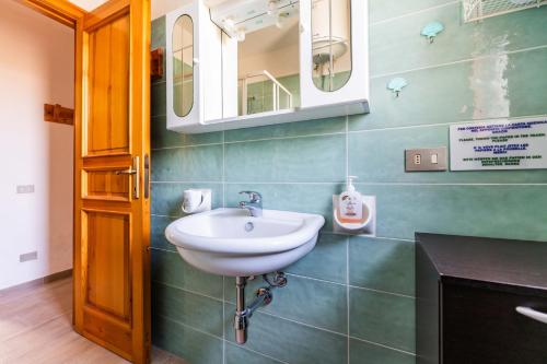 een badkamer met een wastafel en een spiegel bij Elena’s Maison in Solanas