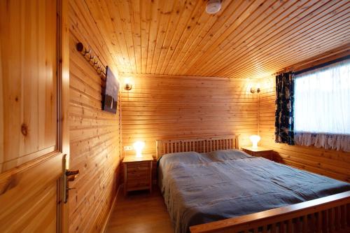 a bedroom with a bed in a wooden room at Ferienhaus 'am Seeufer' in Sietow