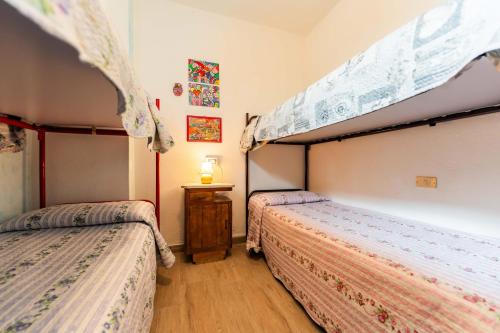 een slaapkamer met 2 bedden en een kleine tafel bij Elena’s Maison in Solanas