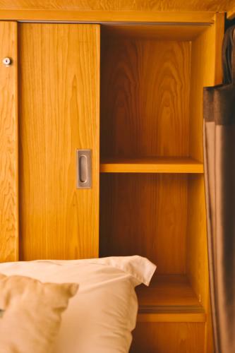 a bedroom with a bed with a wooden headboard at THALAY Cha-am by THA in Cha Am