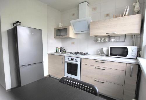 uma pequena cozinha com frigorífico e micro-ondas em Apartment near Akropolis em Klaipėda