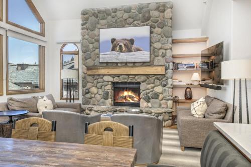 Highlands Westview 300 condo في بيفر كريك: غرفة معيشة كبيرة مع موقد حجري