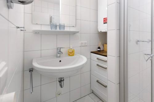 a white bathroom with a sink and a shower at Muggelbude in Gaienhofen
