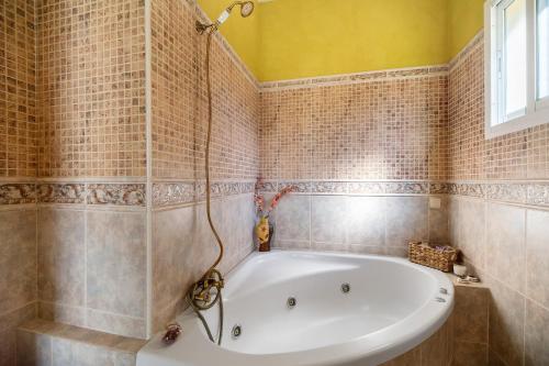 a bathroom with a tub and tiled walls at Goleta in El Puerto de Santa María