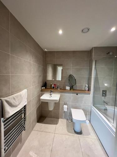 a bathroom with a sink and a toilet and a tub at 2Bed apartment in Media city within walking distance from Old Trafford Stadium in Manchester
